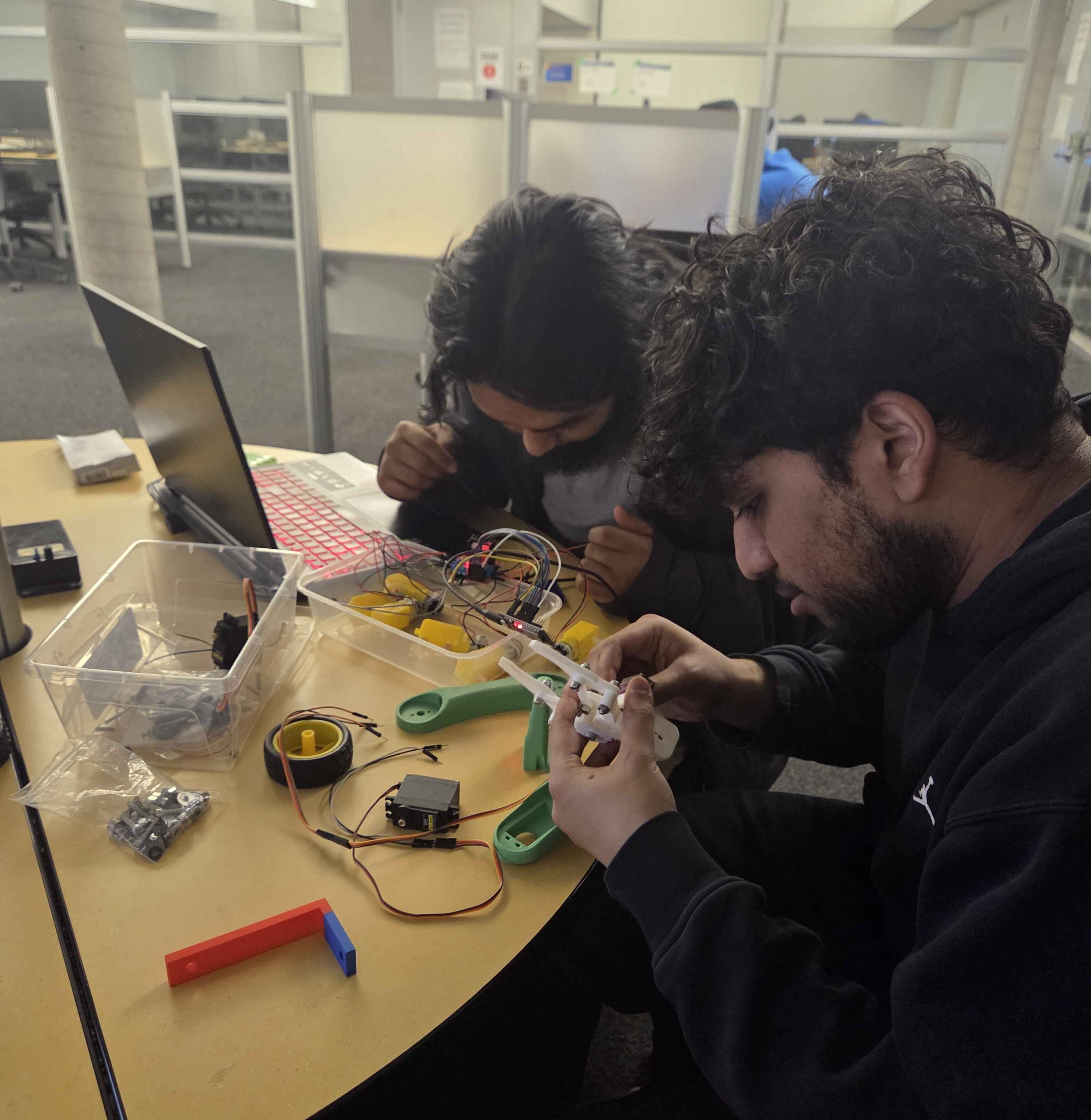Team members assembling and wiring rover components